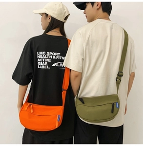Detail view of stylish orange and army green half-moon canvas crossbody bags with straps