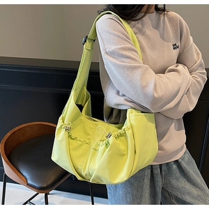 Détail du sac bandoulière en nylon vert fluo avec cordon de serrage et sangle réglable