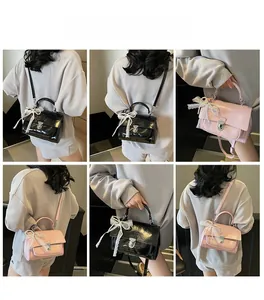 Detailed views of glossy patent leather crossbody bag with lace bow and metal turn-lock