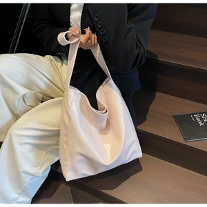 Chic pink leather tote bag styled with a professional outfit on a dark wooden staircase