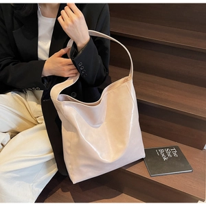Pale pink leather tote bag shown in a stylish street style scene with high fashion appeal