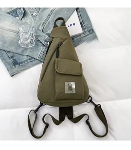 Detail of army green nylon chest bag featuring a bunny patch and tactical pockets