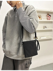 Gray polo sweatshirt with stripe detail paired with a black crossbody envelope bag
