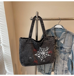 Detail der Gothic-Spinnennetz-Grafik auf der dunkelgrauen Denim-Tragetasche