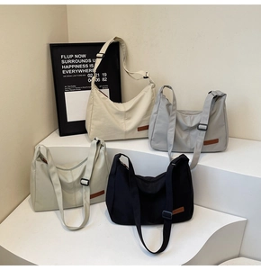 Detail of multi-color semi-moon shoulder bags with adjustable straps and logo patch