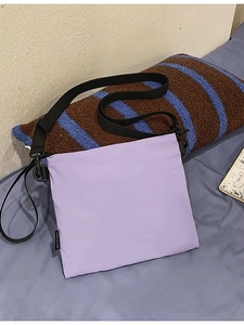 Fashionable light purple envelope crossbody bag with a wide black nylon shoulder strap