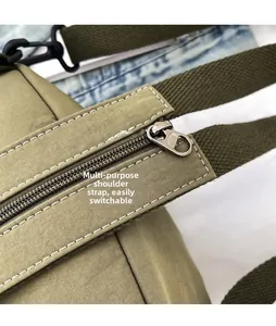 Macro detail of the green nylon crossbody bag featuring sturdy metal zipper and woven strap