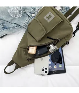 Detailed internal view showing large capacity for iPad and phone in green crossbody bag