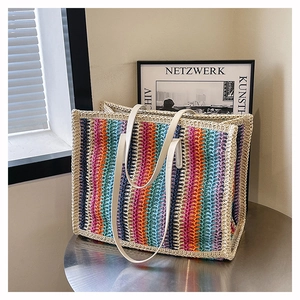 Detailed close-up of colorful striped woven tote bag with white faux leather handles