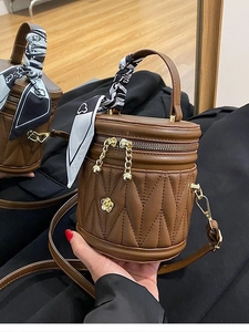 Quilted dark brown bucket bag with gold rose clasp and silk scarf wrapped handle