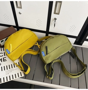 Detail of yellow and olive green nylon crescent cross-body bags with adjustable straps