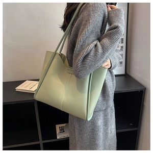 Detail view of large mint green tote bag with sleek shoulder straps and wavy edge design