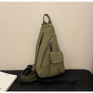 Detailansicht der militärgrünen Canvas-Brusttasche mit Reißverschluss und verstellbarem Gurt