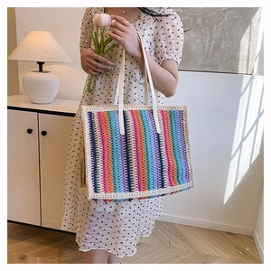 Close-up of colorful striped handwoven straw tote bag for beach and daily vacation use