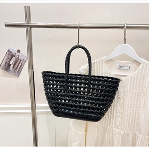 Detailed close-up of a black hollow woven tote bag with glossy texture and mesh design