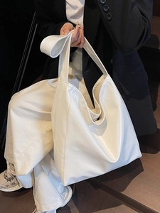 Minimalist cream white PU leather tote bag shown on model in a high-fashion commute style