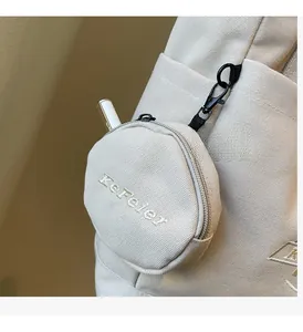 Détail d'une pochette ronde en toile avec broderie KeFeier et mousqueton noir