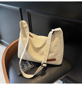 Close-up of cream large tote bag with textured surface and adjustable canvas shoulder strap