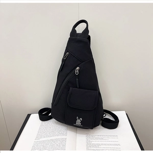 Detail of multi-pocket black nylon sling bag with TANGGUOTU logo on an open book