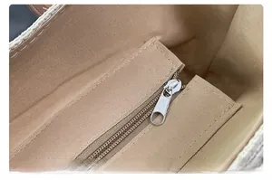 Detail view of khaki straw tote bag interior lining with metal zipper pocket