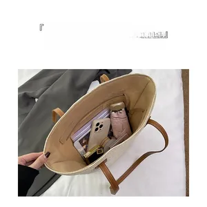 Interior view of straw tote bag showing spacious storage for phone, tablet, and umbrella