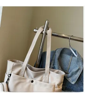 Détail du cabas en toile blanc cassé avec poche à pression et porte-monnaie