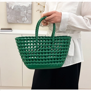 Detail of green woven hollow jelly bag with polished texture and sturdy dual handles