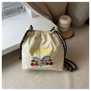 Detailaufnahme der Nylon-Beuteltasche mit Poppy-Stickerei und Kontrast-Kordelzug