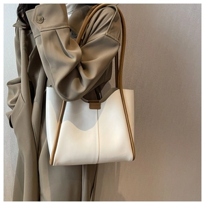 Detail of minimalist tote bag with contrast stitching and long caramel leather straps