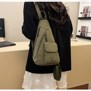 Details der armee-grünen Canvas-Brusttasche mit Hasenprint und Reißverschlüssen