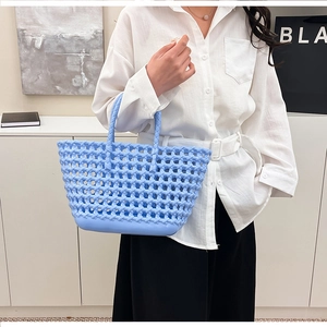 Detail of light blue hollow-out woven silicone tote bag with integrated handles