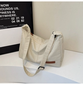 Detail of soft cream-colored tote bag showing fine leather texture and adjustable strap