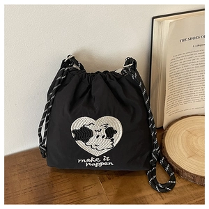 Detail der schwarzen Nylon-Beuteltasche mit Herzbestickung und gewebtem Kordelzug