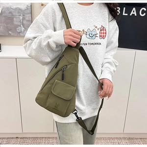 Detailansicht der olivgrünen Nylon-Brusttasche mit mehreren Taschen und verstellbarem Gurt