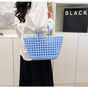 Detail of light blue hollow-out silicone tote bag featuring a diamond woven texture
