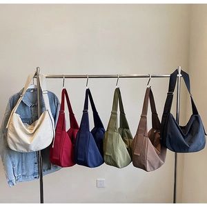 Detailed row of nylon crossbody bags in various colors on a metal display rack