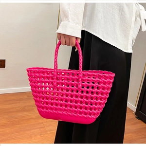 Detail of rose pink hollow woven silicone basket bag featuring solid bottom and handles