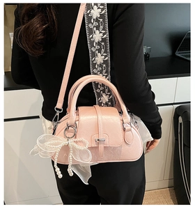 Pink Boston bag detail featuring elegant white lace and a pearl bow charm accessory