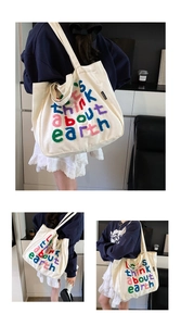 Detalle de letras de colores en bolso tote de lona beige de gran capacidad con bandolera