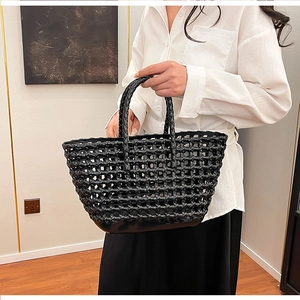 Detail of black woven jelly basket bag featuring hollow-out texture and sturdy handles