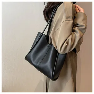 Detail of high-quality black leather tote bag with vertical stitching for daily commute