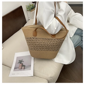 Detail of hand-woven straw tote bag with brown leather straps and hollow mesh texture