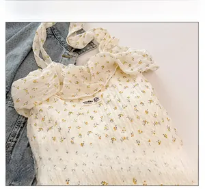 Détails du sac en tissu blanc à fleurs avec bords plissés et étiquette de marque cousue