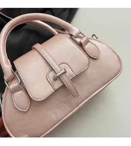 Detailed macro shot of light pink shell bag showing soft leather texture and metal buckle