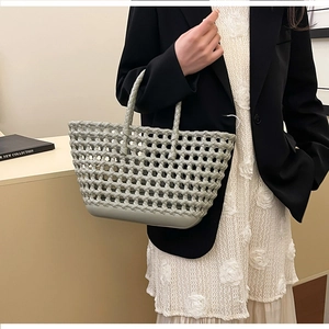 Detail view of the hollow diamond pattern on light grey-green silicone tote bag