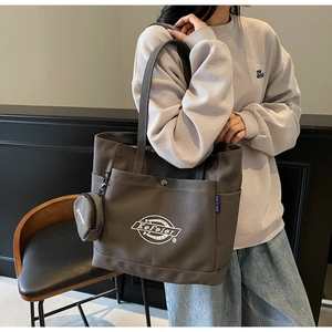 Détail du grand cabas en toile avec petite pochette ronde et imprimé logo blanc