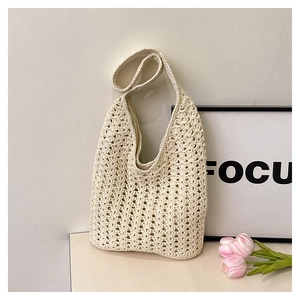 Detail of cream handmade crochet cotton bag featuring intricate openwork weave patterns