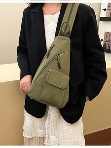 Armeegrüne Canvas-Brusttasche mit mehreren Taschen über einem Blazer getragen