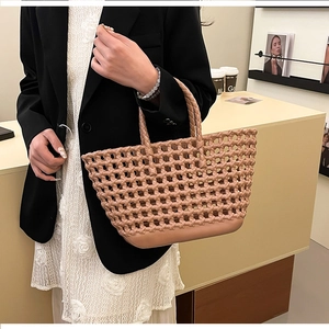 Detail view of pink hollow woven silicone tote bag carried by model in casual style