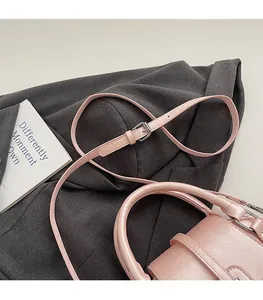 Detail of pink leather handbag showing adjustable shoulder strap with silver buckle hardware